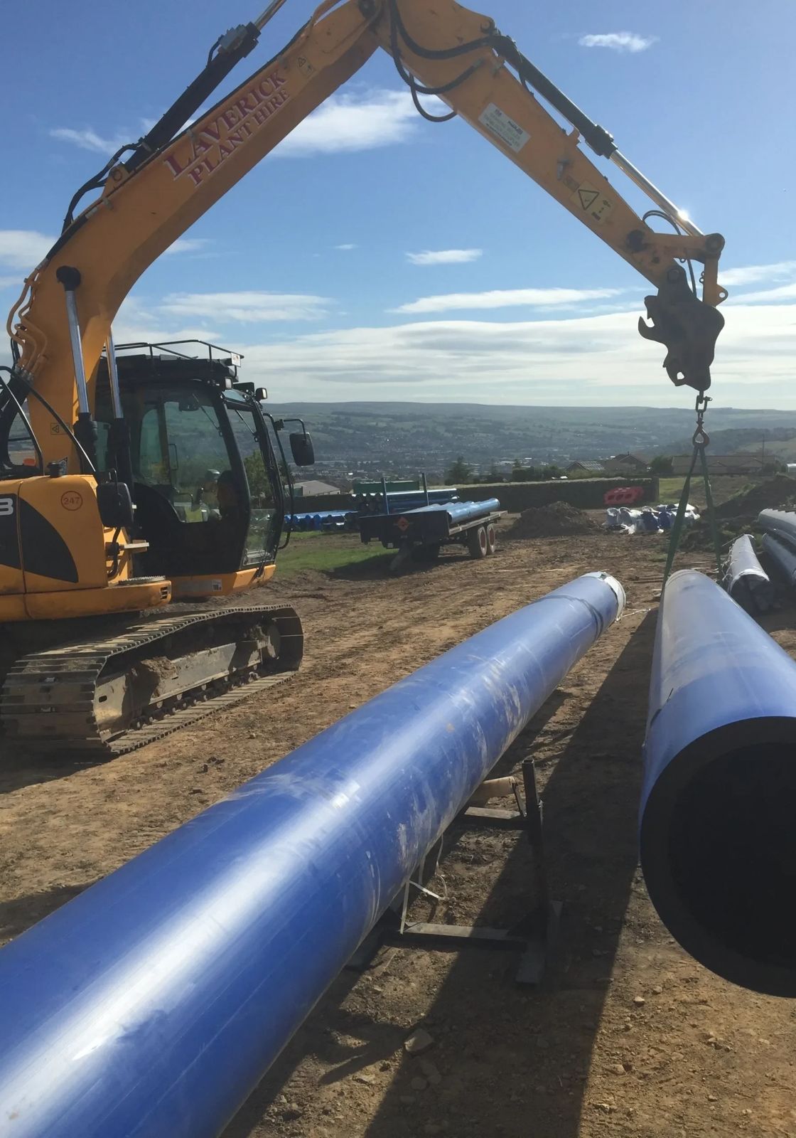 Stormwater drainage pipe being laid in trench during township infrastructure installation